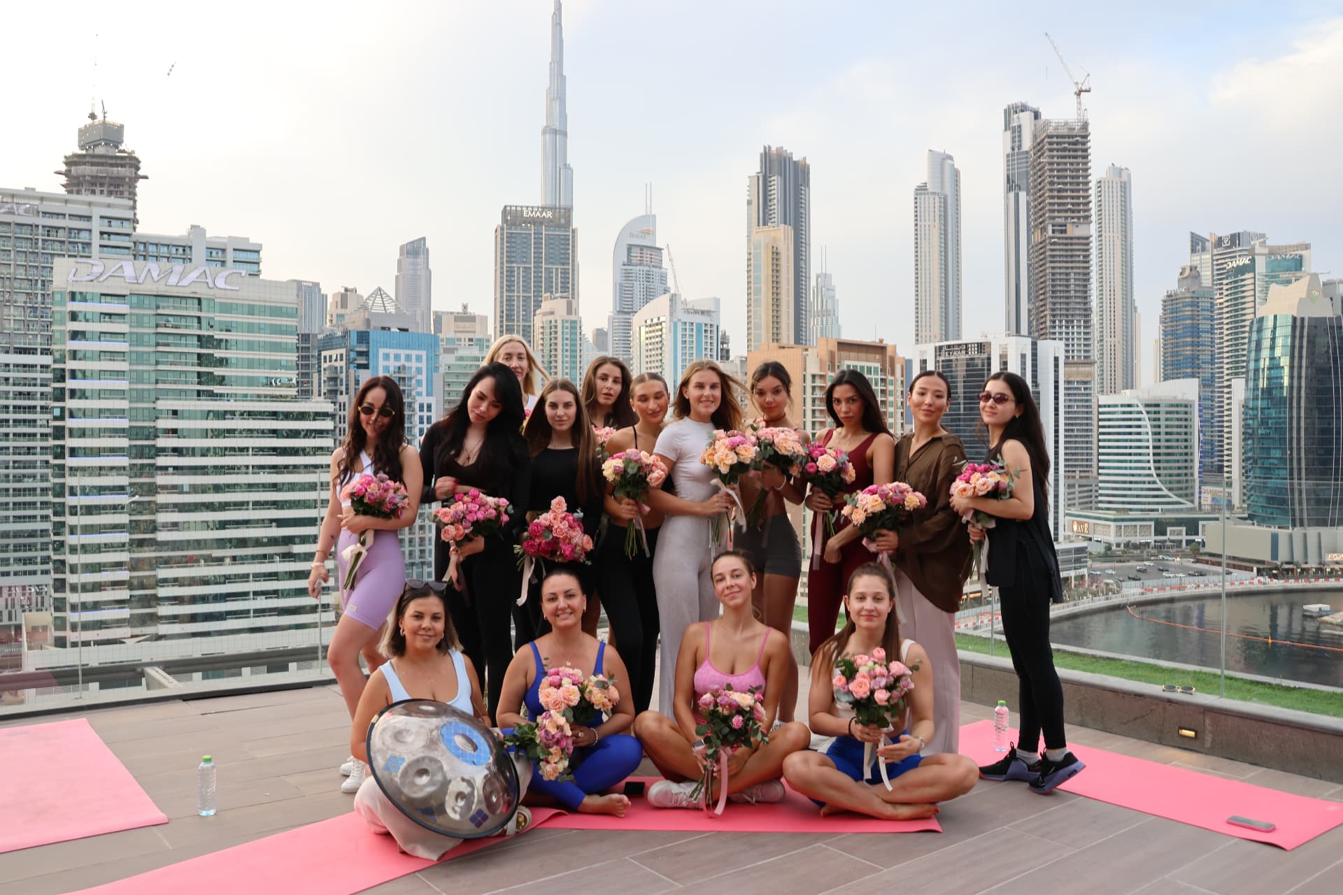 Rooftop yoga gathering with roses and the Burj Khalifa skyline