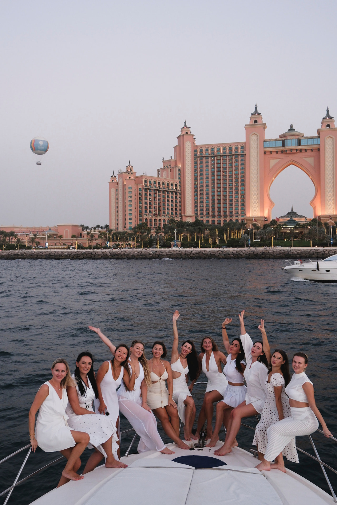 EVA members in white on a yacht in front of Atlantis The Palm at sunset